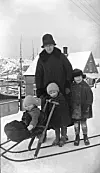 Ein familie på spark i Kristiansund rundt 1920. Foto frå boka: Nordmøre museums fotosamlinger