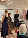 Her viser Anja Leirvik til venstre og Mathilde Haaversen til høgre kjolar frå Hauske Konfeksjon medan Randi Bøe fortel om modellar og stoff.