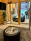 Drive in-suiten har betonggolv med varmekablar, og stovebordet er ein Lamborghini-felg med Pirelli-dekk og glasplate. I sjølve drive-in-delen er det golvsluk der regnvåte bilar kan renne frå seg, og rundt er det brannsikkert glas med utsikt og innsyn til nesten alt.