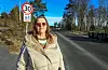 Kvinne står ved en stille boligvei med 30-sone og barn-leker-skilt.