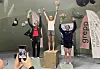 Tre medaljevinnarar på premiepall i klatrehall medan nokon fotograferer dei.