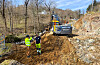 To arbeidarar ved ein gravemaskin frå Birkeland AS på ei oppgraven vegstrekning.